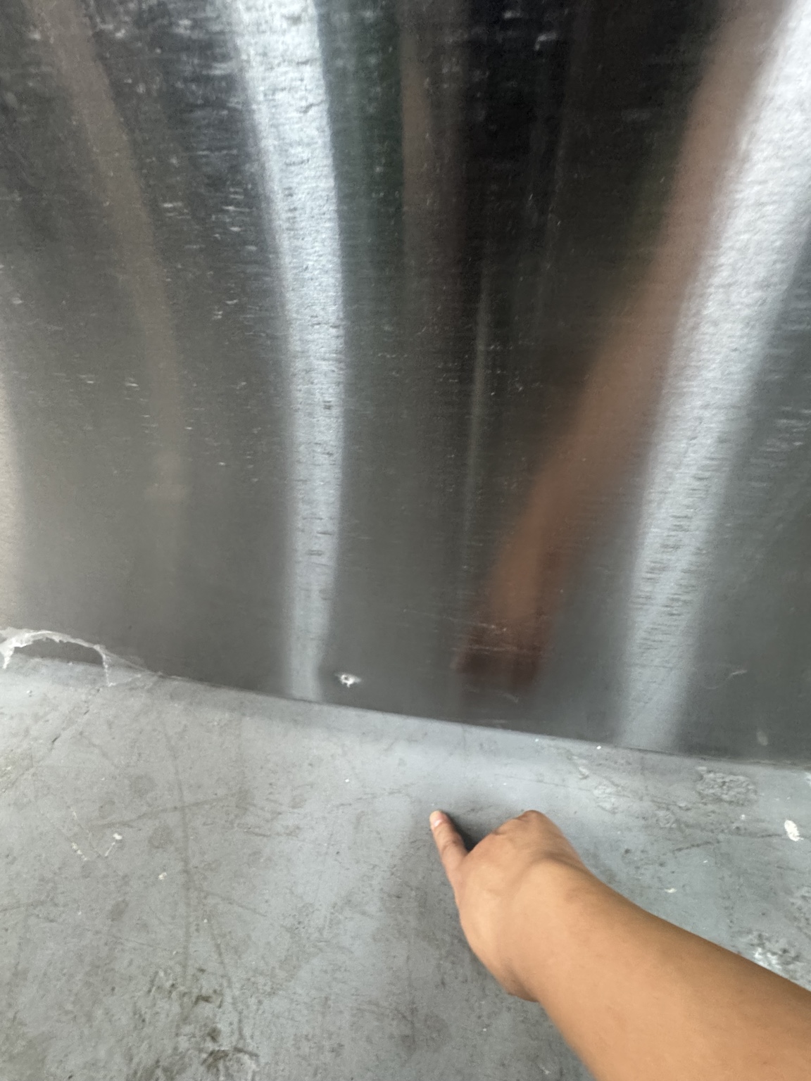 Small cosmetic dent near the bottom of the refrigerator